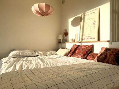 - une chambre avec un lit et une lampe pendant dans l'établissement A 4 minutes de la plage dans le meilleur quartier, à Nice