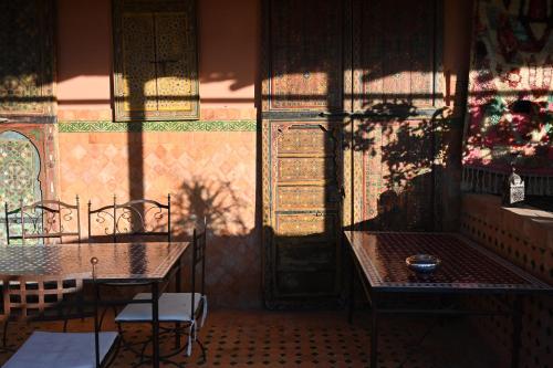 a room with two tables and chairs and a window at Riad le petit ksar in Meknès