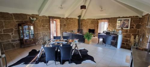 a living room with a table and a stone wall at Quinta da Adarnela in Lagares da Beira