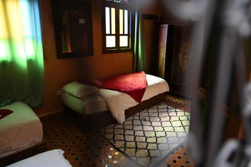 a small bedroom with two beds and two windows at Riad le petit ksar in Meknès