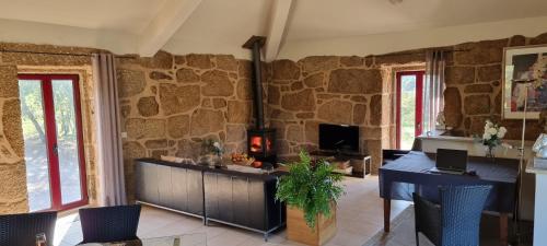 a living room with a stone wall at Quinta da Adarnela in Lagares da Beira