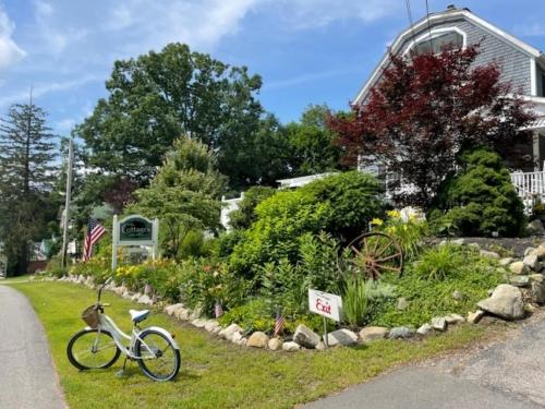 a bike parked in the grass next to a garden at Main House - 3 Story 5 Bed/ 3 Bath - Wolfeboro in Wolfeboro