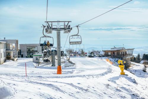 a ski lift with people on it in the snow at Villa Luef in Mönichkirchen