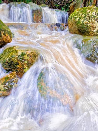 a stream of water flowing over rocks in a river at SZ Samui Glamping in Ban Sa Ket