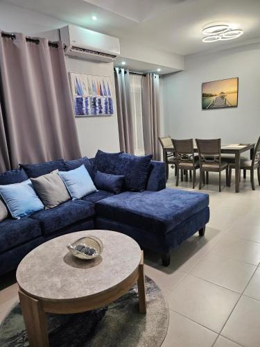 a living room with a blue couch and a table at Blue Water Villa in Point