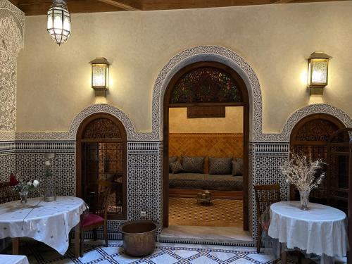 a living room with two tables and a couch at Riad le petit ksar in Meknès