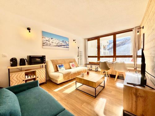 una sala de estar con un sofá y una mesa en 2 Pièces ISOLA 2000 - FRONT DE NEIGE, en Isola 2000