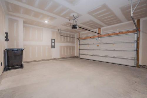 an empty garage with two garage doors and a stove at 5BR 3B, Sleeps 13, Pet Friendly, Garage - Blue in Wilmington