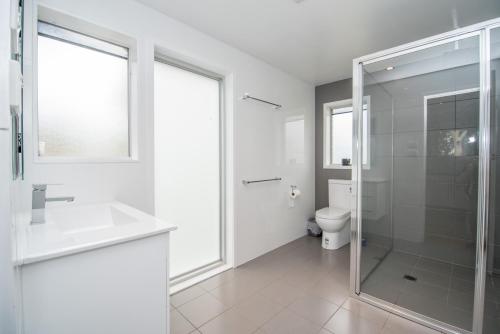 a bathroom with a glass shower and a toilet at Lakeside Cabins & Holiday Village in Sussex inlet