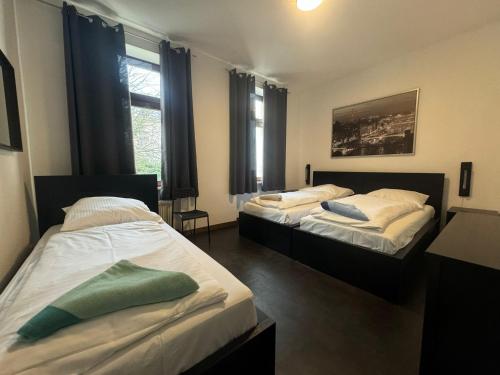 Dos camas en una habitación con dos ventanas. en Best Frankfurt Apartments, en Frankfurt