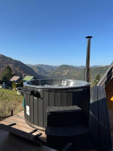 a hot tub on a deck with mountains in the background at Villa Route Rugove in Peje