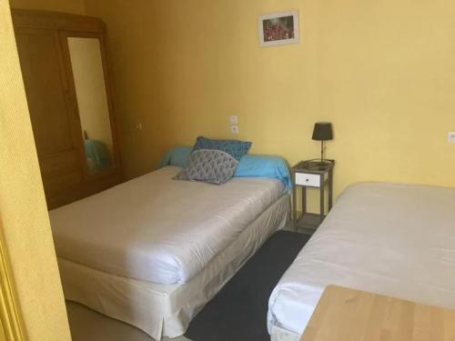 una habitación con dos camas y una mesa con lámpara en Le Bouf Tard CH 3, en Vendôme