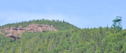 a mountain with a hill with a tower on it at Gite Nycole in Perce