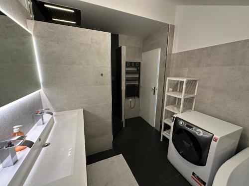 une salle de bain avec une machine à laver et un lavabo dans l'établissement Duplex vue Disneyland , 3 chambres, 2 parkings, à Montévrain
