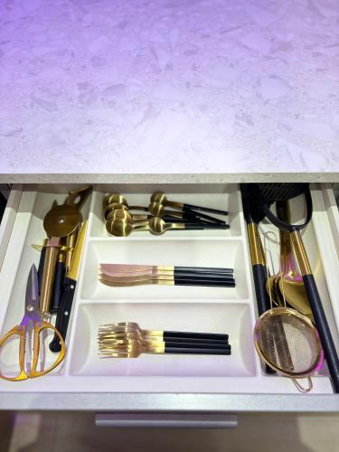 a drawer full of utensils in a cabinet at Lux Stays - Luxury Leeds City Apartment with Jacuzzi & Free Parking in Leeds