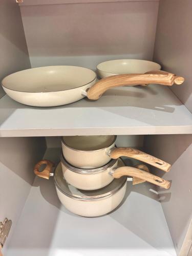 a shelf with bowls and wooden utensils in a refrigerator at Lux Stays - Luxury Leeds City Apartment with Jacuzzi & Free Parking in Leeds
