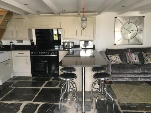 a kitchen with a counter and stools in a room at The Padstow Cottage - Coswarth House in Padstow