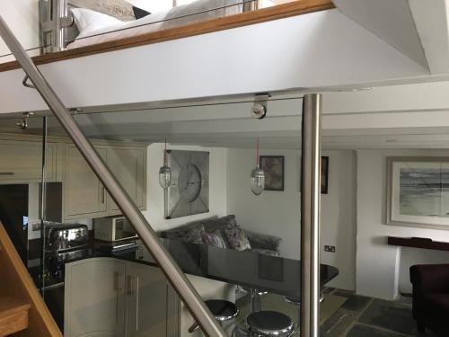 a loft bed in a room with a living room at The Padstow Cottage - Coswarth House in Padstow