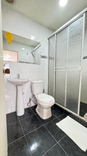 a bathroom with a toilet and a sink and a shower at Hotel Balcones de Bocagrande in Cartagena de Indias