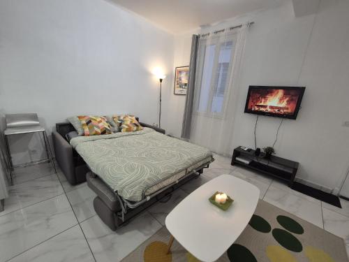 une chambre avec un lit, une table et une télévision dans l'établissement Studio rénové au centre ville (15 min de la plage), à Nice