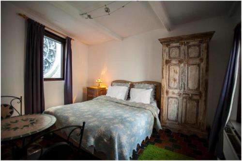a bedroom with a bed and a table and a window at Living History - Drie Koningen in Antwerp