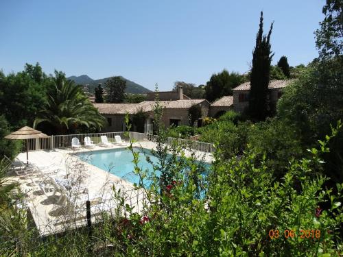 - une piscine dans une cour avec des chaises et des arbres dans l'établissement Les Voutes, à Propriano