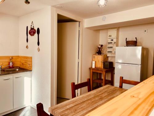 une cuisine avec une table et un réfrigérateur dans l'établissement La Cave aux Lumières - Proche centre-ville - 2 chambres - Wifi, à Renaison