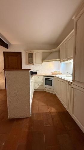 a kitchen with white cabinets and a counter top at 2 bedroom apt near Como lake in Morbio Inferiore