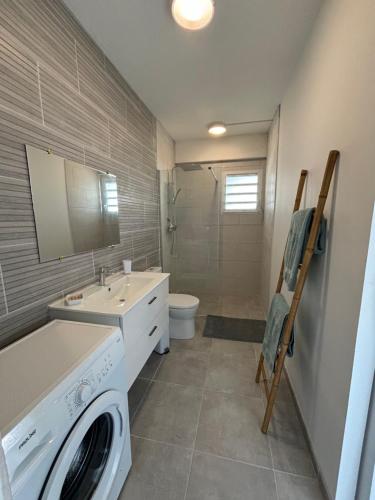 a bathroom with a washer and dryer in it at Villa Ansalane in Quartiers Anse à lʼÂne