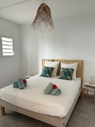 a bedroom with a large white bed with pillows at Villa Ansalane in Quartiers Anse à lʼÂne
