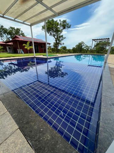 a swimming pool with blue tiles on the ground at Suíte Canário in Colinas Do Sul