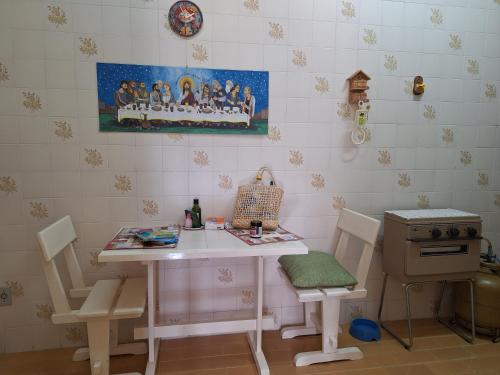 a small room with a table and chairs and a stove at Apartamento Gracioso ao lado do Parque das Águas in Caxambu
