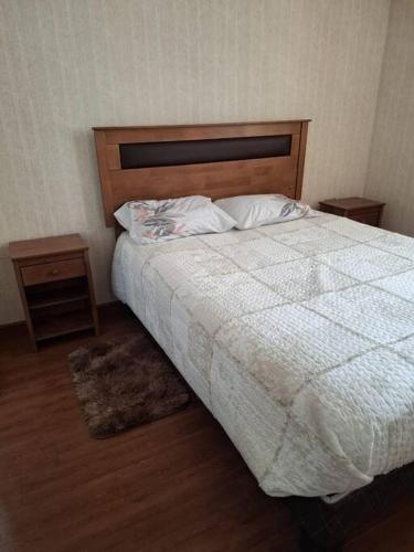 a bedroom with a bed with two night stands and two tables at Espacioso Depto Con Parking in Chorrillos