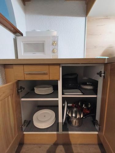Il comprend une petite cuisine avec un four micro-ondes et des étagères. dans l'établissement Résidence Vallée Blanche, à Sallanches