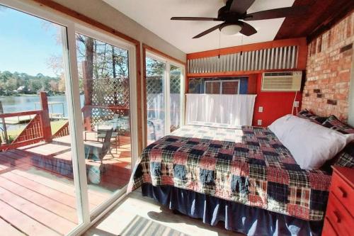 une chambre avec un lit et un balcon avec vue dans l'établissement Newly Remodeled Lakehouse on Private Lake sleeps 8, à Woodville