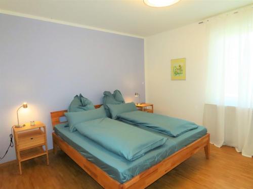 a bedroom with a bed with blue pillows at Ferienwohnung Seestraße Ost in Immenstaad am Bodensee