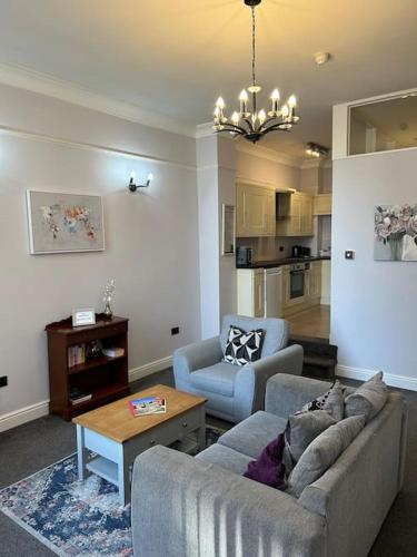 a living room with a couch and two chairs and a table at 10 Thurnams House in Carlisle