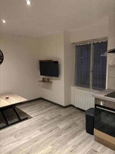 un soggiorno con TV a schermo piatto a parete di Appartement meublé T1 Lussac les Chateaux a Lussac-les-Châteaux