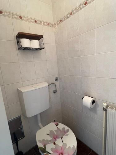 a bathroom with a toilet with a flower painted on it at Chic Relax - Best located City & Nature Trip Apartment in Mödling