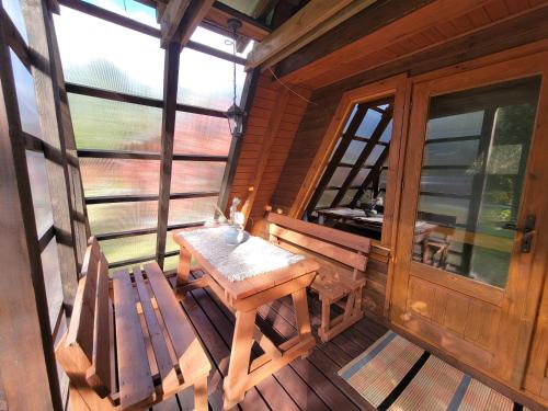 a wooden porch with a wooden table and two chairs at Chaty Kaszubskie in Łąkie