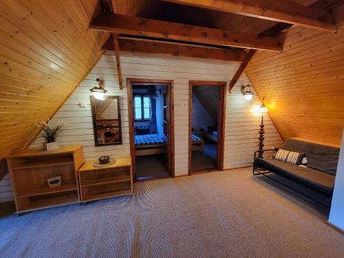 a attic room with a couch and a mirror at Chaty Kaszubskie in Łąkie