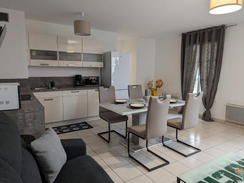 une cuisine et un salon avec une table et des chaises dans l'établissement Chic appartement à 5 minutes de bus de Disneyland, à Serris