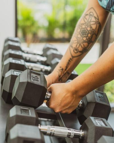 a person with a tattoo on their arm holding a dumbbell at Governors Village - 1,2,3 & 4 Bedroom Apartments on Seven Mile Beach Corridor in George Town