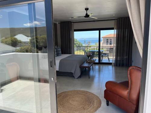 a bedroom with a bed and a view of a balcony at The Cliff Villa Boutique Guesthouse in Hermanus