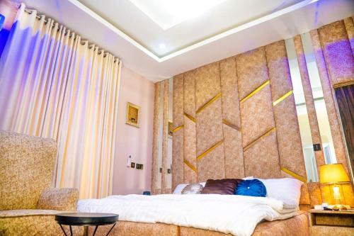 a bedroom with a bed and a wall with yellow arrows at Kay&M Homes in Garki