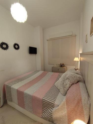 a bedroom with a bed and a tv on the wall at San Nicolas Apartaments in Fuengirola