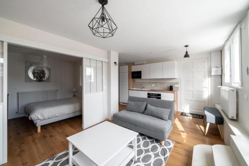 ル・プレシ・ロバンソンにあるAppartement cosy avec belle terrasseのソファとテーブルのあるリビングルーム