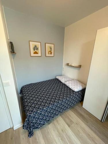 une chambre avec un lit dans le coin d'une pièce dans l'établissement Studio cosy 10min de Paris & CDG, à Drancy