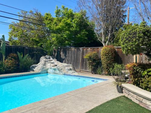 a swimming pool in a backyard with a fence at Relaxing 3-room Apartment with yard pool, Near Santana Row in San Jose