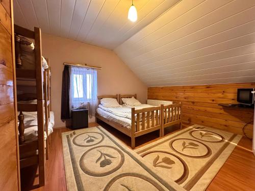 a bedroom with a crib and a bed in a room at Family Hotel Parnas 2250 in Gudauri